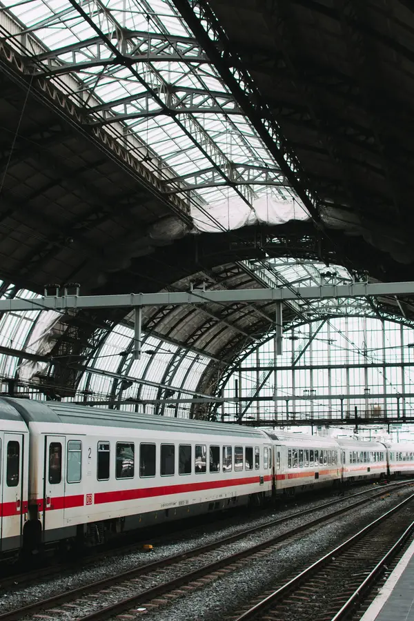 Weit gespannte gläserne Gewölbehalle eines historischen Kopfbahnhofs