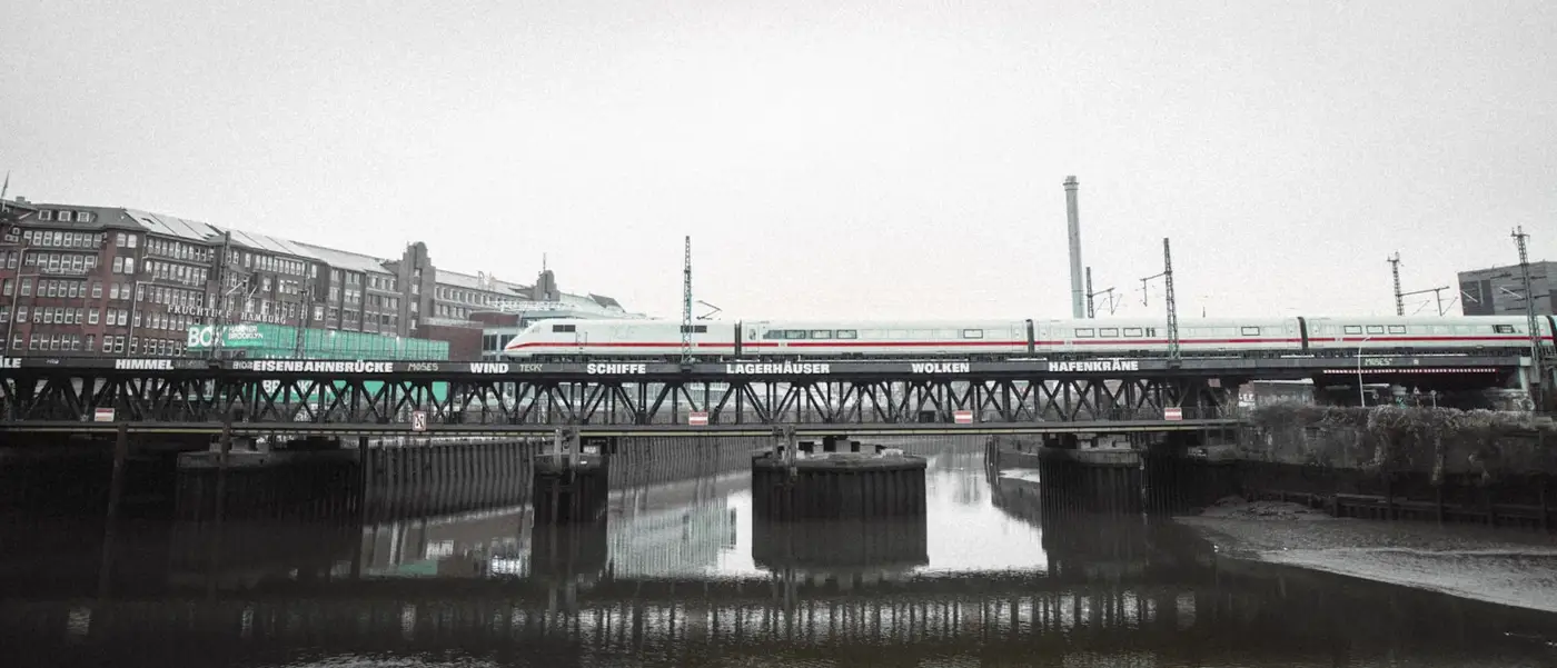 Mehrere Eisenbahnbrücken über einem Fluss, im Dunst hintereinander gestaffelt