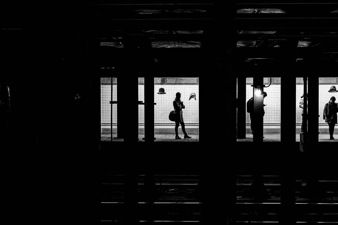 Schwarzweißaufnahme: Silhouetten von Reisenden in den offenen Türen eines Zuges